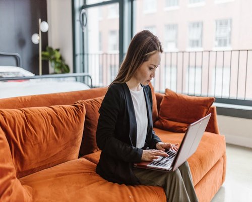Young professional working comfortably on a laptop in a well-lit apartment living room in Santiago